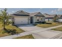 Inviting single-story home with a two-car garage, well-maintained lawn, and landscaped garden beds at 301 Sunset Point Dr, Ormond Beach, FL 32174