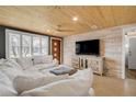 Bright living room with wood ceilings, neutral tones, and a large comfortable sofa with lots of natural light at 308 Normandy Ave, New Smyrna Beach, FL 32169
