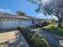 Well-maintained single-story home with an attached garage and mature landscaping at 309 & 311 Sea Hawk Ct, Edgewater, FL 32141