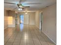 Spacious living room featuring tiled floors, ceiling fans, and sliding glass doors to the patio at 309 & 311 Sea Hawk Ct, Edgewater, FL 32141