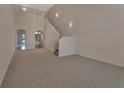 Unfurnished living room featuring high ceilings, carpet, and a staircase at 3546 Casalta Cir, New Smyrna Beach, FL 32168