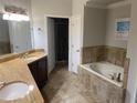 Bathroom with soaking tub, double sinks with granite counters and walk in shower at 424 Luna Bella Ln # 226, New Smyrna Beach, FL 32168
