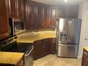 Kitchen features dark wood cabinets, stainless steel appliances and stone countertops at 424 Luna Bella Ln # 226, New Smyrna Beach, FL 32168