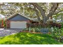 Lovely single Gathering home with a two car garage and a lush front yard with mature trees at 4426 Saxon Dr, New Smyrna Beach, FL 32169