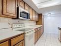 Kitchen featuring wooden cabinets, white appliances, and ample countertop space at 448 Shorewood Ln, New Smyrna Beach, FL 32168