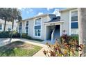 Exterior view of a condo building featuring a light gray facade, blue accents, and well-maintained landscaping at 4860 S Atlantic Ave # 1030, New Smyrna Beach, FL 32169