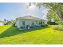 Manicured backyard featuring green lawn and patio area with chairs at 662 Wellesley Ct, New Smyrna Beach, FL 32168