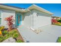 Close-up of the front of the house showcasing the blue front door and two-car garage at 662 Wellesley Ct, New Smyrna Beach, FL 32168