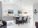 Bright, open-concept kitchen with a vaulted ceiling, center island, stainless appliances and barstool seating at 751 Pine Shores Cir, New Smyrna Beach, FL 32168