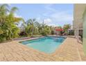 Inviting backyard pool area surrounded by lush landscaping and a brick-paved patio at 921 Duncan Rd, South Daytona, FL 32119