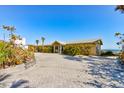 Exterior shot of the house with a large driveway and tropical landscaping at 921 N Atlantic Ave, New Smyrna Beach, FL 32169