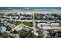 Aerial view of a blue home near the beach, with a marked path to a beach walkover at 923 Locust St, New Smyrna Beach, FL 32169