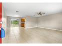 Bright living room featuring tile floors, sliding glass doors to the backyard, and a ceiling fan at 1043 Beulah Dr, Edgewater, FL 32132