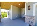 Close up of front porch featuring stained wood ceiling and stone accents at 1100 Loch Linnhe Ct, New Smyrna Beach, FL 32168