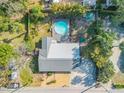 Aerial view showcasing the house, circular pool, deck, and lush backyard surrounded by trees at 128 Dixwood Ave, Edgewater, FL 32132