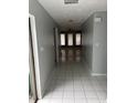 Hallway showcasing an open concept leading to a living area with tile flooring and neutral wall colors at 1774 Concert Rd, Deltona, FL 32738