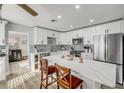 Modern kitchen with white cabinetry, stainless steel appliances, and a marble waterfall island with seating at 1855 Needle Palm Dr, Edgewater, FL 32141