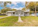 Cozy single-story home with a manicured lawn, mature trees, metal roof and an inviting front entrance at 254 Tanner St, New Smyrna Beach, FL 32168