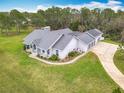 Wide aerial shot displaying the roof, large lawn, screened in pool, and four-car garage at 2590 Erena Dr, New Smyrna Beach, FL 32168