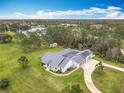 Expansive aerial view of the property featuring a lake, lush greenery, and long driveway at 2590 Erena Dr, New Smyrna Beach, FL 32168