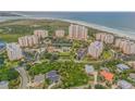 Panoramic aerial view of coastal condominium community with lush landscaping and beach access, set against the ocean backdrop at 263 Minorca Beach Way # 801, New Smyrna Beach, FL 32169