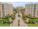 Grand entrance to a condo community with palm-lined drive, manicured gardens and gate houses leading to ocean view buildings at 263 Minorca Beach Way # 801, New Smyrna Beach, FL 32169