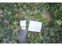 Aerial view of a home with metal roof nestled in a lush, green wooded lot at 2995 Ragis Rd, Edgewater, FL 32132