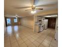 Open-concept living room and kitchen area with tile floors and ceiling fans at 309 Sea Hawk Ct, Edgewater, FL 32141