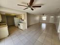 Open-concept living room featuring tiled floors, ceiling fans, and a view into the kitchen at 311 Sea Hawk Ct, Edgewater, FL 32141