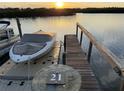 Boat dock with a boat that is partially covered, next to a peaceful river at 47 Jacaranda Cay Ct # 470, New Smyrna Beach, FL 32169