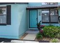 Charming front entrance with a bright blue door, black trim, and well-maintained landscaping at 47 Jacaranda Cay Ct # 470, New Smyrna Beach, FL 32169