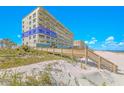 Condominium building on a sunny day near the sandy beach with a blue sky at 4767 S Atlantic Ave # 404, Ponce Inlet, FL 32127