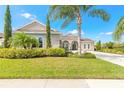 Attractive home with manicured lawn, mature trees, and an elegant arched entryway at 512 Romdini St, New Smyrna Beach, FL 32168