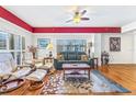 Well-lit living room with hardwood floors and a large window with plantation shutters at 5300 S Atlantic Ave # 5-407, New Smyrna Beach, FL 32169