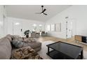 Bright living room with modern ceiling fan, neutral decor, and ample natural light from arched windows at 5431 Landis Ave, Port Orange, FL 32127