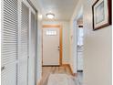 Inviting hallway with laminate flooring, closet, and decorative front door with light-wood trim at 704 Hillville Dr, Port Orange, FL 32127