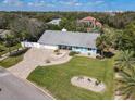 Beautiful home featuring a charming light blue exterior, lush landscaping, and a picturesque neighborhood surrounded by mature trees at 86 Rains Ct, Ponce Inlet, FL 32127