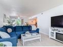 A cozy living room featuring a comfortable blue sofa, beachy decor, and lots of natural light at 910 Maple St # A & B, New Smyrna Beach, FL 32169