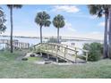 Beautiful backyard featuring a wooden bridge, palm trees, and a serene waterfront view at 944 S Peninsula Dr # 5010, Daytona Beach, FL 32118