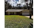 Attractive single-story home with a two-car garage, stone accents, and a well-maintained lawn at 2380 Captain Butler Trl, New Smyrna Beach, FL 32168