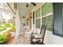 Inviting front porch with comfortable seating and a view of the landscaped yard at 105 Azalea Cir, New Smyrna Beach, FL 32168