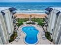 Aerial view of condo complex with pool, ocean views, and lounge chairs at 1275 Ocean Shore Blvd # 5050, Ormond Beach, FL 32176