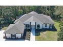 Stunning exterior of a white home with black accents, well-maintained landscaping, and gray roof at 1350 Scarlett Trl, New Smyrna Beach, FL 32168