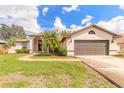 Attractive single-Gathering home with a two-car garage, complemented by lush landscaping and blue skies at 15 Katrinas Dr, Ormond Beach, FL 32174
