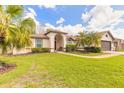 Inviting home with a well-manicured lawn, complemented by tropical palm trees and sculpted shrubbery at 15 Katrinas Dr, Ormond Beach, FL 32174