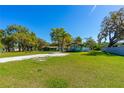 Charming home with a covered porch, lush green lawn, and complemented by mature trees at 191 Howes St, Oak Hill, FL 32759