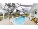 Enclosed pool area featuring a sparkling pool, white tile flooring and a seating area at 2307 Needle Palm Dr, Edgewater, FL 32141