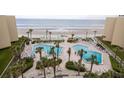 Beautiful pools with ample lounge seating surrounded by tropical landscaping and ocean views at 2401 S Atlantic Ave # A604, New Smyrna Beach, FL 32169