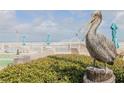 Pelican statue overlooking outdoor lounge area with tables, chairs, and umbrellas at 2401 S Atlantic Ave # D301, New Smyrna Beach, FL 32169
