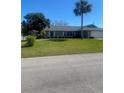 Single-story home with a well-manicured lawn and mature landscaping, creating curb appeal at 2409 Victory Palm Dr, Edgewater, FL 32141
